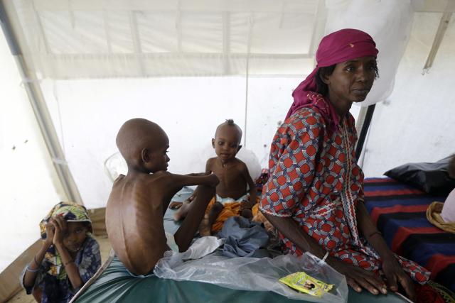 In this photo taken Monday Aug. 29, 2016, a woman with her malnourished children sit at a feeding centre run by Doctors Without Borders in Maiduguri, Nigeria. (AP) In this photo taken Monday Aug. 29, 2016, a woman with her malnourished children sit at a feeding centre run by Doctors Without Borders in Maiduguri, Nigeria. (AP)