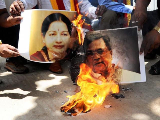 Pro-Kannada organisation activists burn posters of Tamil Nadu CM Jayalalithaa and Karnataka CM Siddaramaiah in protest against the Supreme Court order on Cauvery water, in Bengaluru. (PTI) Pro-Kannada organisation activists burn posters of Tamil Nadu CM Jayalalithaa and Karnataka CM Siddaramaiah in protest against the Supreme Court order on Cauvery water, in Bengaluru. (PTI)