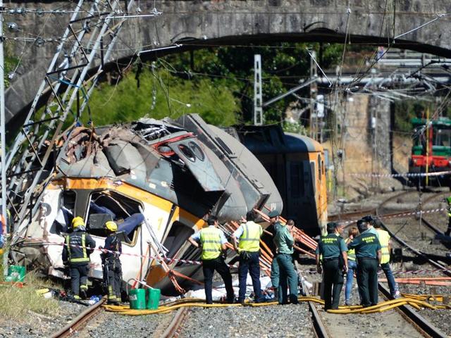 Spanish Guardia Civil policemen, firefighters and security members stand past the wreckage of a train derailed in O Porrino. (AFP Pho) Spanish Guardia Civil policemen, firefighters and security members stand past the wreckage of a train derailed in O Porrino. (AFP Pho)