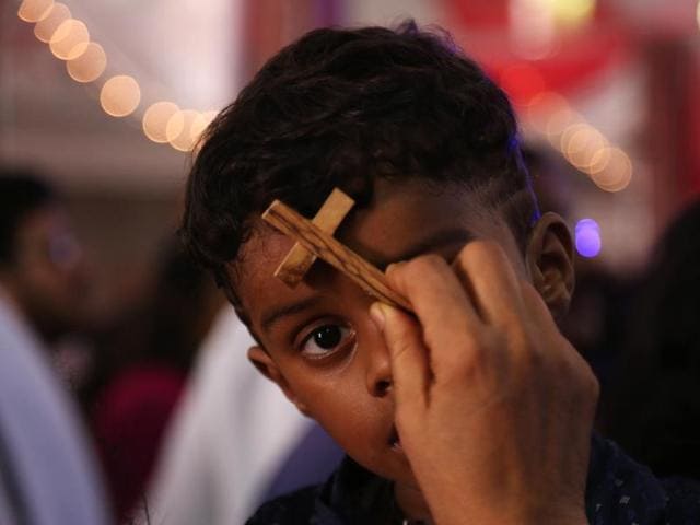 An Indian Catholic nun holds a crucifix to the forehead of a child to bless him during the annual feast of the birth of Virgin Mary at the Shrine of Our Lady of Health on September 8 in Hyderabad, India. (AP) 