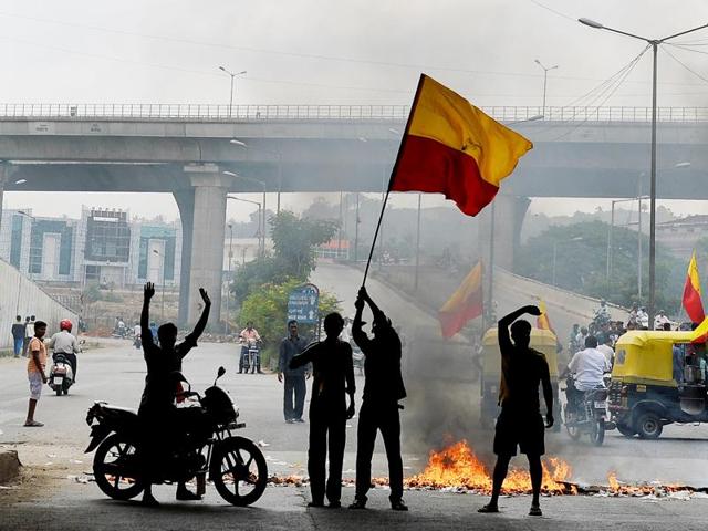 Indian activists wave the Karnataka flag as they block traffic on a major connecting road during a statewide strike in Bengaluru on September 9, 2016. Agitation in the southern Indian state of Karnataka has been increasing since the recent Supreme Court order to the state to release 15,000 cusecs of water from the River Cauvery each day to the neighbouring state of Tamil Nadu.  (AFP) 