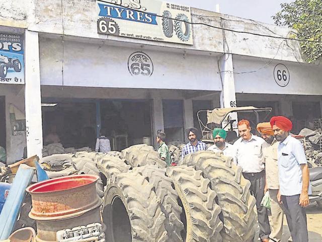Health and MC officials at a tyre shop during their anti-dengue operation in the Jahazgarh area of Amritsar on Friday.(HT Photo)