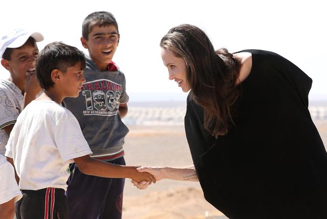 US actor and UNHCR special envoy Angelina Jolie talks to children as she arrives at a Syrian refugee camp in Azraq in northern Jordan. (AFP)
