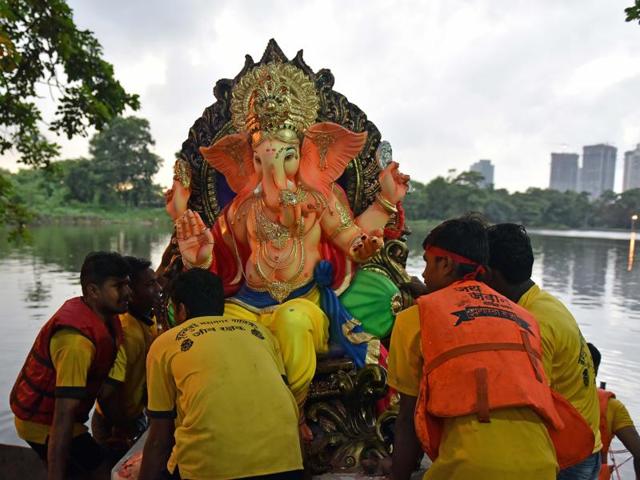 Devotees immerse a Ganpati idol at a lake in Aarey colony on September 9. (Pratham Gokhale/HT PHOTO)