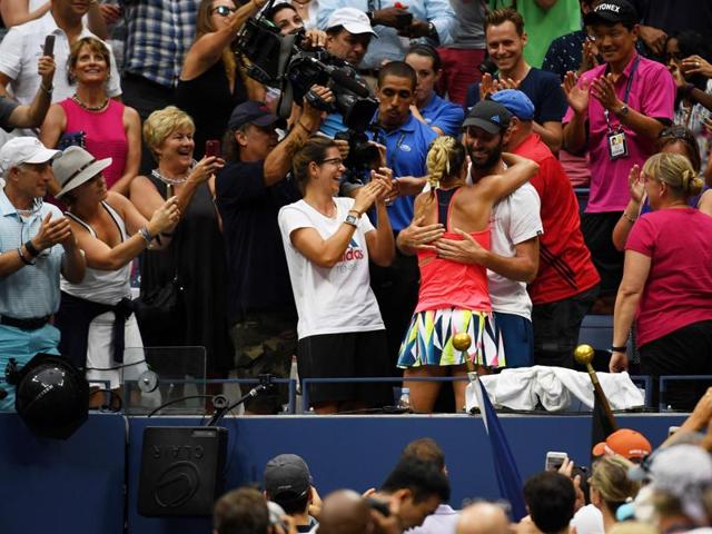 Kerber climbs up into her box and hugs her coach. (AFP) Kerber climbs up into her box and hugs her coach. (AFP)