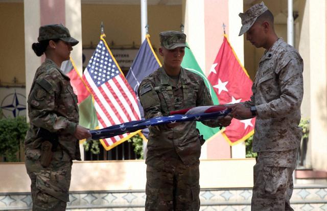 US soldiers roll their flag during a ceremony to commemorate the Sept 11, 2001 terrorist attack on the World Trade Center in New York, in Resolute Support headquarters, in Kabul, Afghanistan. (AP Photo) US soldiers roll their flag during a ceremony to commemorate the Sept 11, 2001 terrorist attack on the World Trade Center in New York, in Resolute Support headquarters, in Kabul, Afghanistan. (AP Photo)
