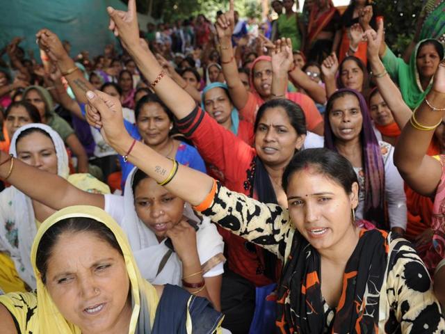 Asha workers at the health department office in Noida on the fourth day of the strike to demand minimum wages and recognition of jobs.(Burhaan Kinu/HT Photo)