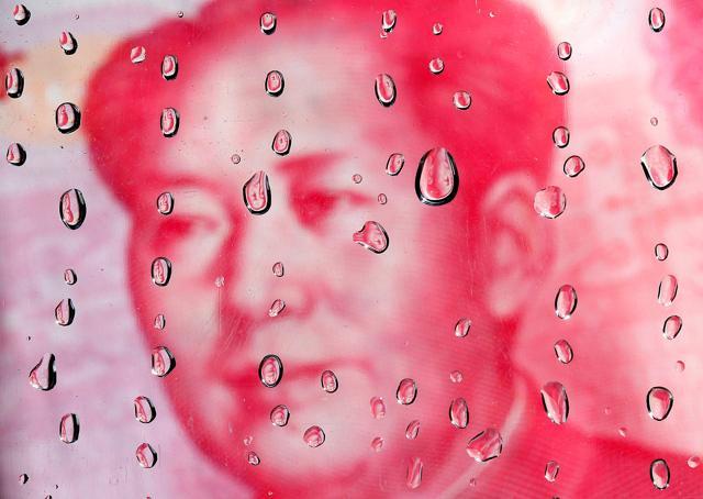 A portrait of former Chinese leader Mao Zedong on a yuan banknote is reflected in water droplets in this picture illustration taken in Taipei October 8, 2010. (REUTERS)