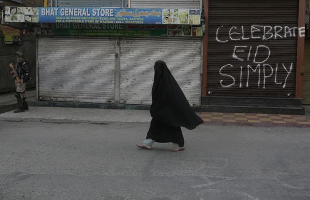 A veiled Kashmiri woman walks past a graffiti on a closed shop at a deserted market during a strike in Srinagar. (AP Photo) A veiled Kashmiri woman walks past a graffiti on a closed shop at a deserted market during a strike in Srinagar. (AP Photo)
