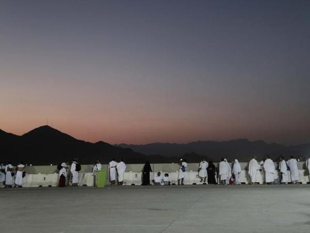 Pilgrims watch sunrise before they make their way to cast stones at a pillar on the first day of Eid al-Adha, in Mina, Saudi Arabia. (AP Photo)