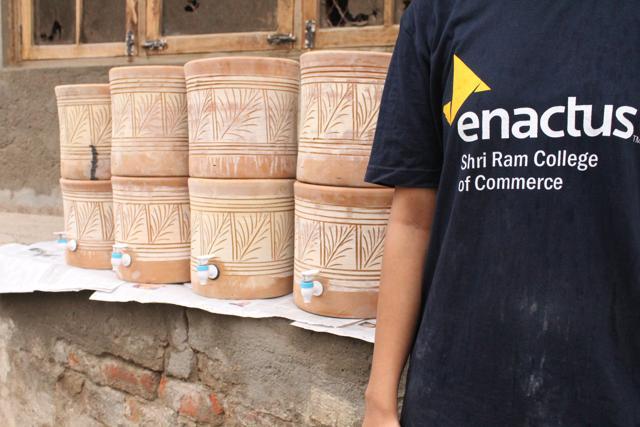Two candles are installed between two clay pots, which have a tap installed for easy flow of water.