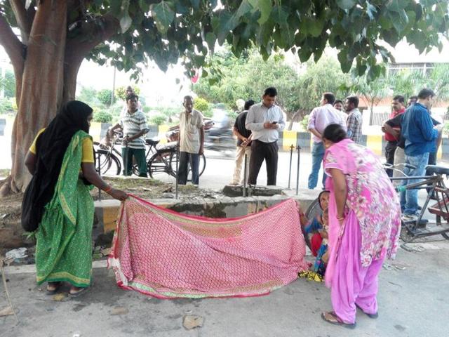 Two women with her and some passerby covered Punam with dupattas and helped her deliver the male child on the roadside in Jalandhar on Tuesday.(HT Photo) Two women with her and some passerby covered Punam with dupattas and helped her deliver the male child on the roadside in Jalandhar on Tuesday.(HT Photo)