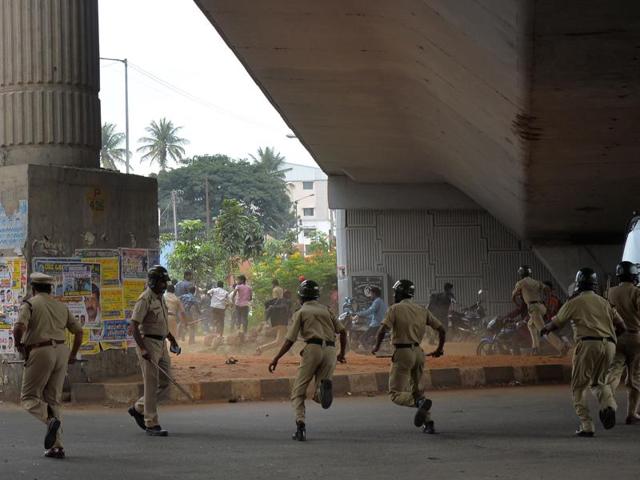 Police personnel chase agitated activists as the Cauvery water dispute erupted into violence following the Supreme Court's order to release water to Tamil Nadu, in Bengaluru. (AFP Photo) 