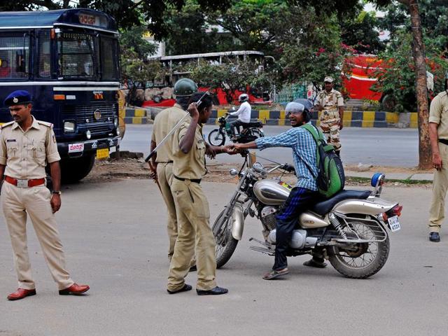 Police stop a man during a curfew over Cauvery water dispute, in Bengaluru. (Reuters Photo)