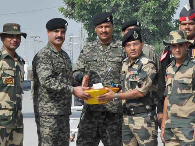 BSF commandant Sudeep (right) exchanging sweets with Pak Rangers wing commander Bilal on the occasion of Eid on the India-Pakistan border at the Attari-Wagah check post near Amritsar on Tuesday.(HT Photo)