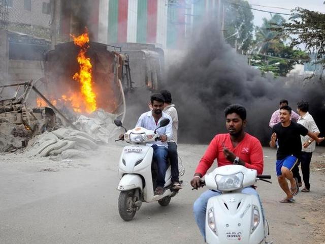 Men ride a motorcycle past a lorry in Bengaluru, which was set on fire by protesters after the Supreme Court ordered Karnataka state to release 12,000 cubic feet of water per second every day from the Cauvery river to neighbouring Tamil Nadu. (Reuters) Men ride a motorcycle past a lorry in Bengaluru, which was set on fire by protesters after the Supreme Court ordered Karnataka state to release 12,000 cubic feet of water per second every day from the Cauvery river to neighbouring Tamil Nadu. (Reuters)