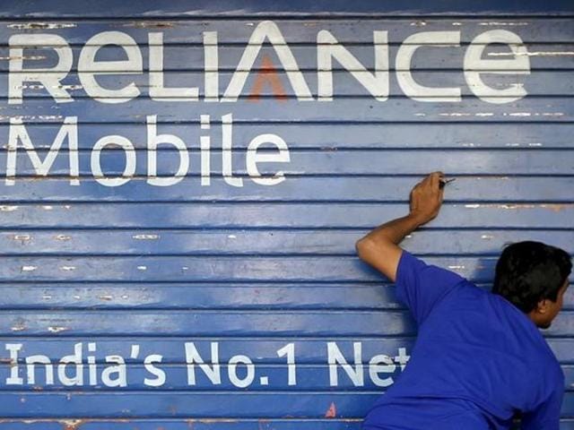 A man opens the shutter of a shop painted with an advertisement of Reliance Communications in Mumbai.(Reuters) A man opens the shutter of a shop painted with an advertisement of Reliance Communications in Mumbai.(Reuters)