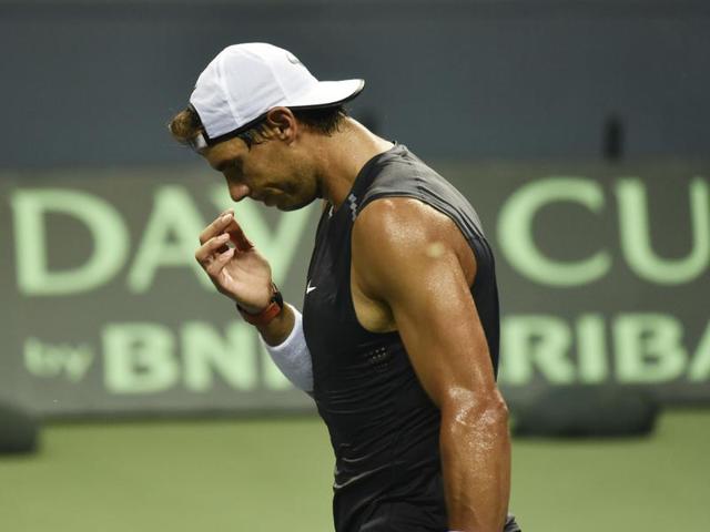 Nadal wipes sweat off his face as he walks towards the baseline. (Vipin Kumar/HT PHOTO)