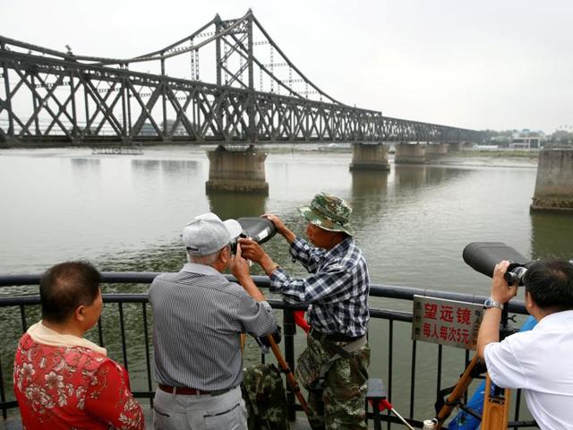 People look through binoculars towards North Korea from the destroyed bridge across Yalu River that once linked North Korea's Sinuiju and Dandong, China's Liaoning province, September 10, 2016. (Reuters) People look through binoculars towards North Korea from the destroyed bridge across Yalu River that once linked North Korea's Sinuiju and Dandong, China's Liaoning province, September 10, 2016. (Reuters)