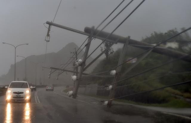 Cars drive past collapsed power lines, that partially block the road, as super typhoon Meranti skirts Pingtung county in southern Taiwan. (AFP) Cars drive past collapsed power lines, that partially block the road, as super typhoon Meranti skirts Pingtung county in southern Taiwan. (AFP)
