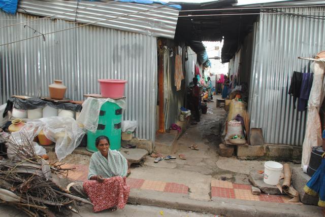 A lady worker sits outside her house -- one of the metal sheds in Sanjay Gandhi Nagar A lady worker sits outside her house -- one of the metal sheds in Sanjay Gandhi Nagar