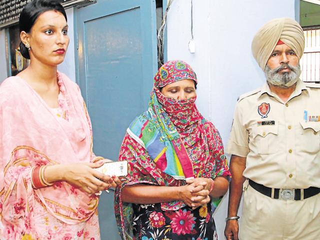 Prime accused Manjit Kaur (centre) in police custody at Ramdass police station in Ajnala on Wednesday. (HT Photo) Prime accused Manjit Kaur (centre) in police custody at Ramdass police station in Ajnala on Wednesday. (HT Photo)