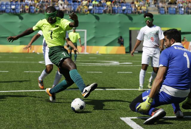 Brazil's Jefinho, left, kicks the ball as Iran' goalkeeper Meysam Shojaeiyan blocks, during a men's group A preliminary soccer 5-a-side match. (AP) Brazil's Jefinho, left, kicks the ball as Iran' goalkeeper Meysam Shojaeiyan blocks, during a men's group A preliminary soccer 5-a-side match. (AP)