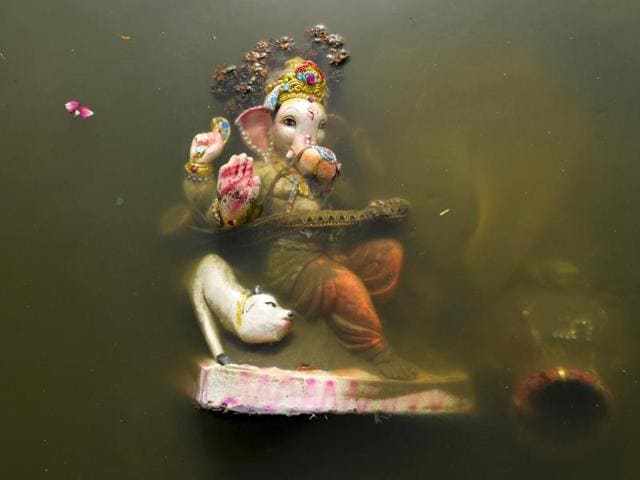 The barely thriving Yamuna does not have enough water for towering idols to be submerged in. (Burhaan Kinu/HT PHOTO)
