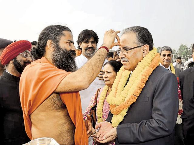 Yoga guru Ramdev welcomes Nepalese Prime Minister Pushpa Kamal Dahal in Haridwar on Sunday.(HT photo)