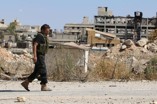 A rebel fighter walks by damaged buildings near Castello road in Aleppo, Syria. (Reuters) A rebel fighter walks by damaged buildings near Castello road in Aleppo, Syria. (Reuters)