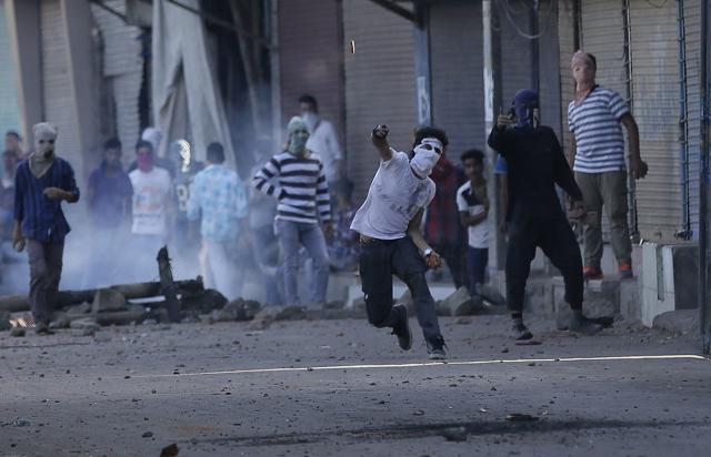 A masked Kashmiri protester throws a stone at security forces during a protest in Srinagar, Wednesday, Sept. 7, 2016. (AP)