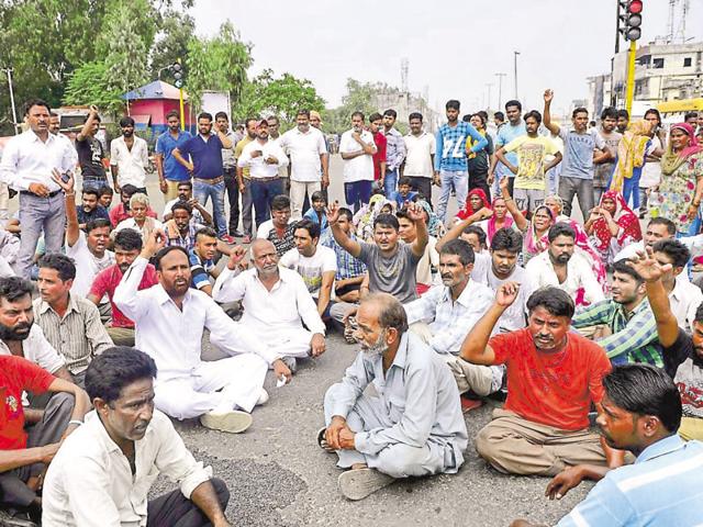 The family and municipal sanitation workers during a protest on Jagraon Bridge in Ludhiana on Saturday. (Gurminder Singh/HT) The family and municipal sanitation workers during a protest on Jagraon Bridge in Ludhiana on Saturday. (Gurminder Singh/HT)