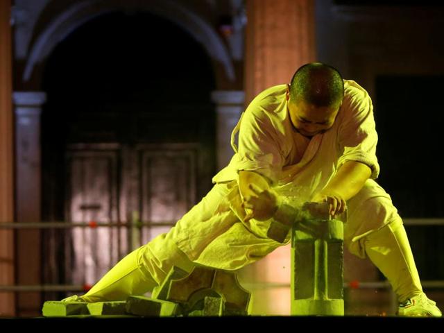 A Shaolin monk of the Dengfeng Zhongyue Shaolin Boxing Culture Troupe breaks bricks with his bare hands. (REUTERS)