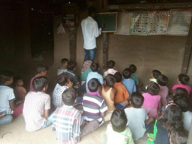Villagers help children cross a rivulet at Matiyamel village.(HT photo)