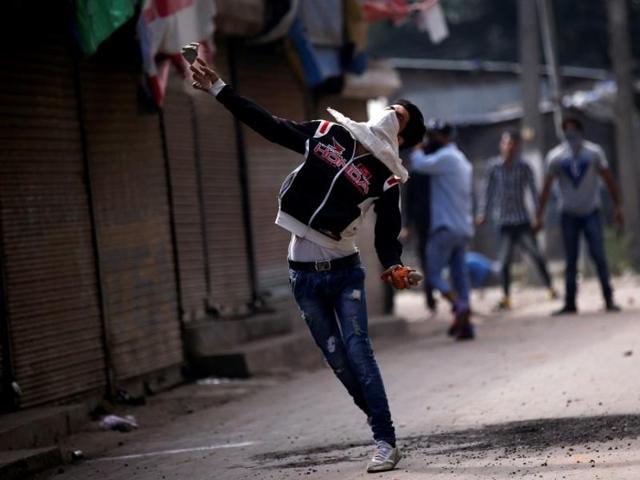 A protester throws a stone towards police during a protest against the recent deaths in Kashmir.(Reuters)