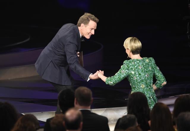 Bryan Cranston, left, helps Sarah Paulson on stage at the 68th Primetime Emmy Awards at the Microsoft Theater in Los Angeles. (AP)