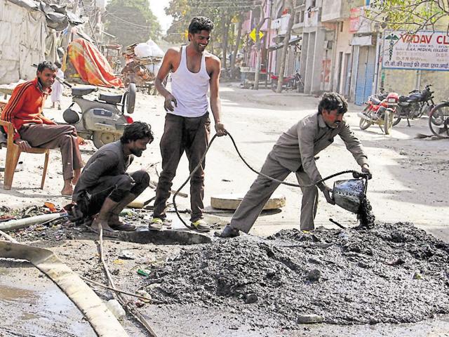 Sewermen cleaning a manhole without protective gear in EWS colony in Ludhiana.(HT Photo) Sewermen cleaning a manhole without protective gear in EWS colony in Ludhiana.(HT Photo)
