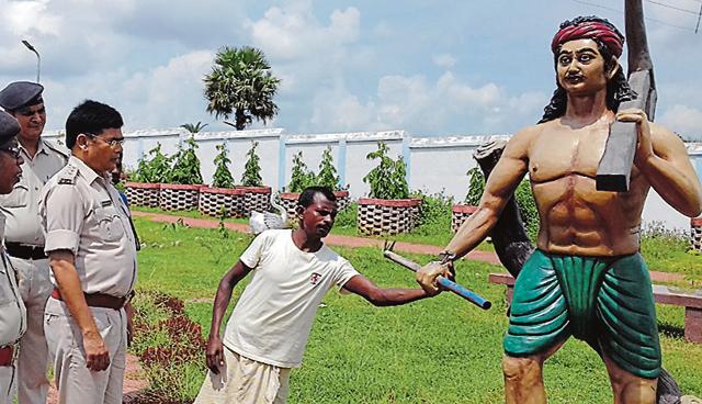 A villager shows one of the damaged statues to police officers at Bhognadih village in Sahibganj district on Sunday.(HT Photo)