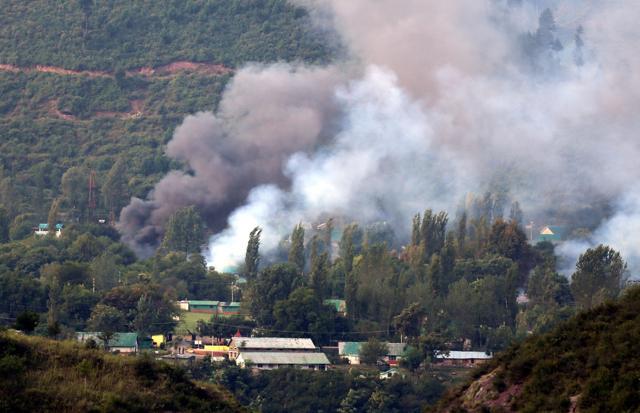 Smoke rises from the army base under attack by militants in the town of Uri, west of Srinagar on Sunday. (HT Photo)