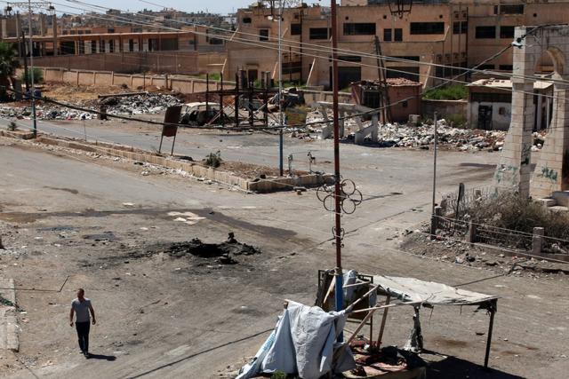 A man walks near a hole in the ground after an airstrike on Sunday in the rebel-held town of Dael, in Deraa Governorate, Syria. (Reuters Photo) A man walks near a hole in the ground after an airstrike on Sunday in the rebel-held town of Dael, in Deraa Governorate, Syria. (Reuters Photo)