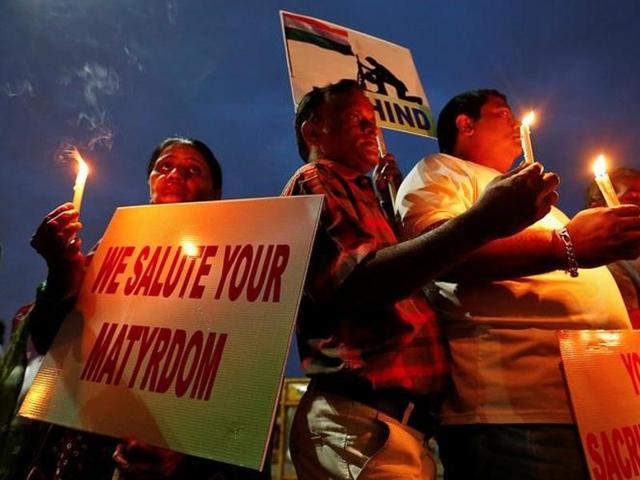 People hold candles and placards during a vigil for the soldiers who were killed after gunmen attacked an Indian Army base in Kashmir's Uri on Sunday, in Mumbai.(Reuters)