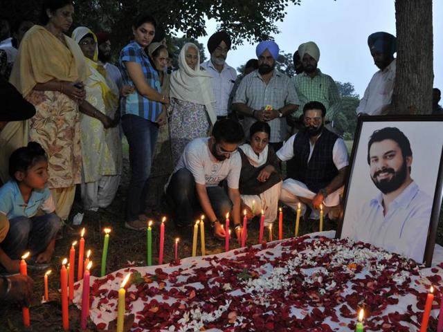 Sippy Sidhu’s mother Deepinder Kaur (sitting, centre) among the relatives and friends lighting a candle at the Sector-27 park where he was found murdered.(Keshav Singh/HT Photo)