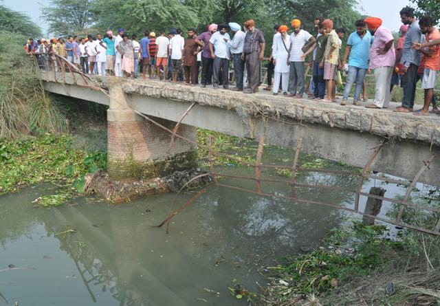 Residents gather at the bridge where the accident took place. (Sameer Sehgal/HT Photo)