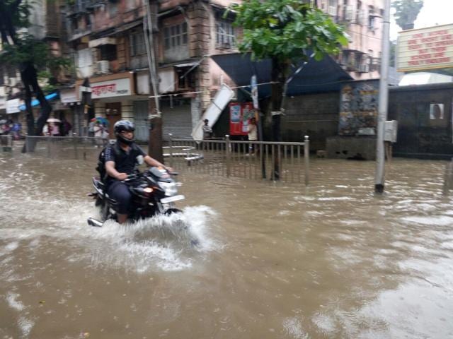 A biker rides through a waterlogged street at Hindmata in Parel, Mumbai, on Thursday. (Anshuman Poyrekar/ HT Photo) A biker rides through a waterlogged street at Hindmata in Parel, Mumbai, on Thursday. (Anshuman Poyrekar/ HT Photo)
