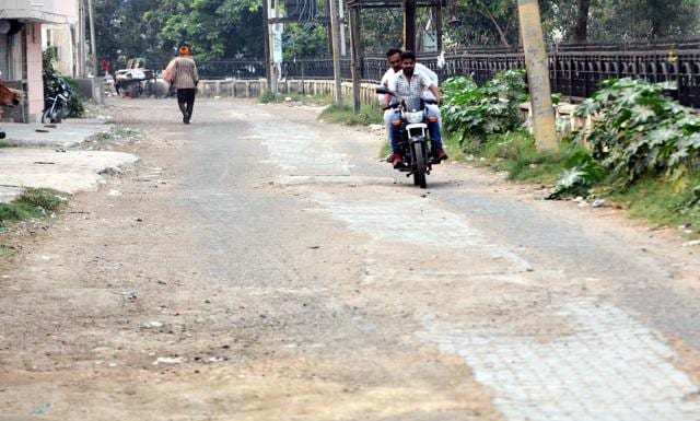 A view of the potholed road near the Kali Mata mandir on which. according to MC, the repair work has already started. (Bharat Bhushan/HT Photo) A view of the potholed road near the Kali Mata mandir on which. according to MC, the repair work has already started. (Bharat Bhushan/HT Photo)