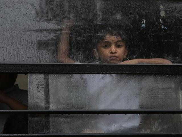 A boy looks out from the window of his school bus during a rain shower in Mumbai on Tuesday. (AP) A boy looks out from the window of his school bus during a rain shower in Mumbai on Tuesday. (AP)