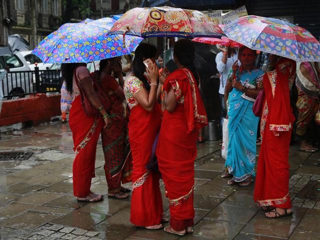 Women stand outside a railway station holding umbrellas during a rain shower in Mumbai. (AP) Women stand outside a railway station holding umbrellas during a rain shower in Mumbai. (AP)
