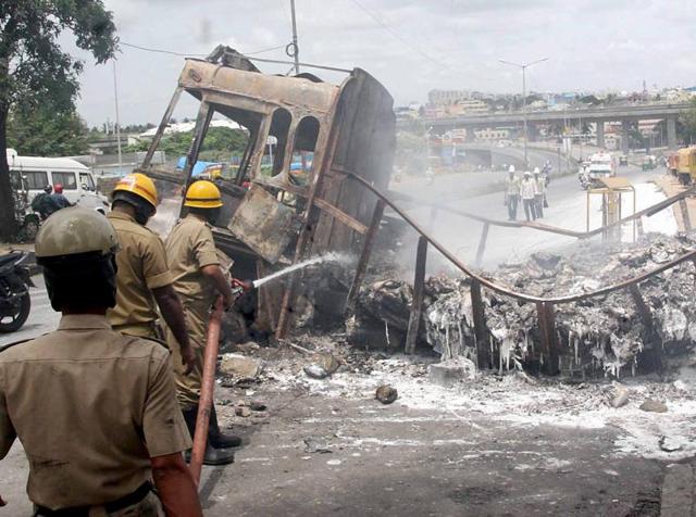 Fire men douse a torched truck in Bengaluru after violent pro-Kannada activists rampaged through the city over the Cauvery water row. (PTI) Fire men douse a torched truck in Bengaluru after violent pro-Kannada activists rampaged through the city over the Cauvery water row. (PTI)