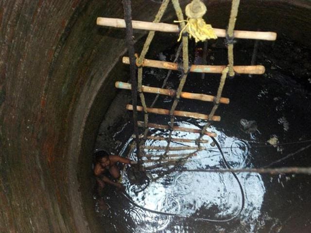 A worker cleans up a 150-year-old well inside the Central Jail in Indore on Thursday.(Arun Mondhe /HT photo)