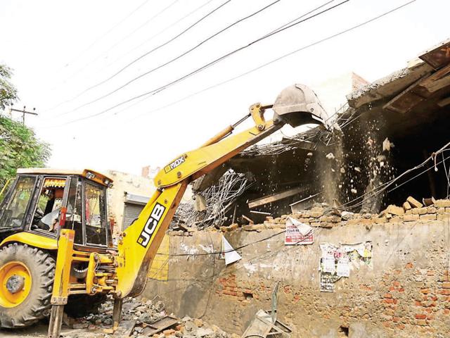 JCB machine demolishing an illegal structure near Qila Mubarak in Bathinda on Thursday.(Sanjeev Kumar/HT)